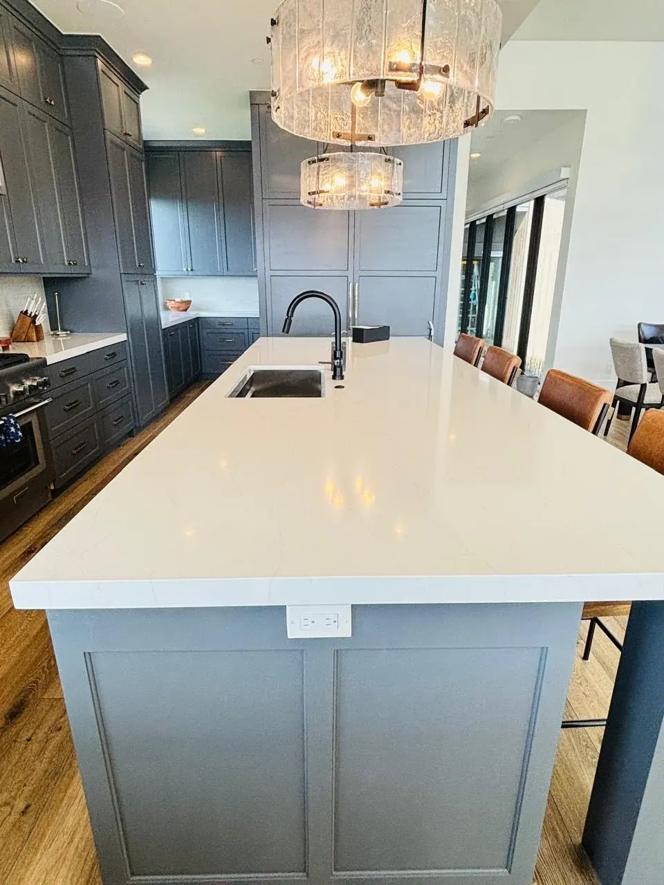 A clean kitchen island with pendant lights