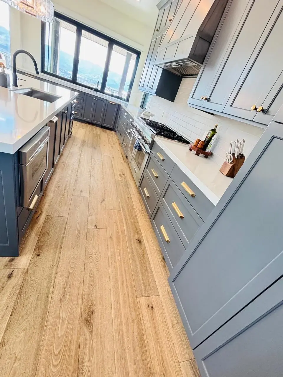 A long, clean kitchen with hardwood floors